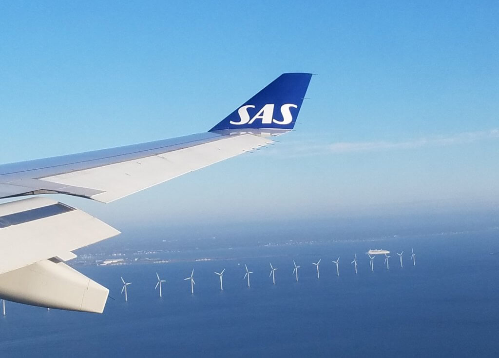 First glimpse of Copenhagen from the wing of my airplane, with a row of off-shore wind turbines in the water.