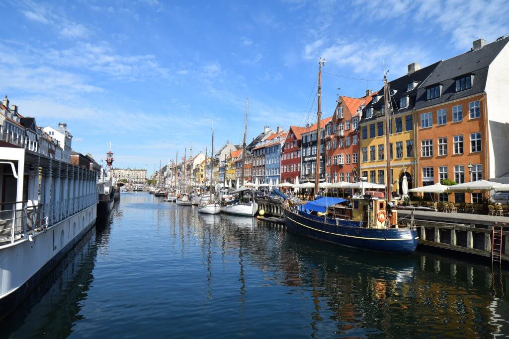 Famous view of Nyhavn in Copenhagen. Sailboats and colorful buildings line the canal. This was one of my favorite stops during my 24 hours in Copenhagen